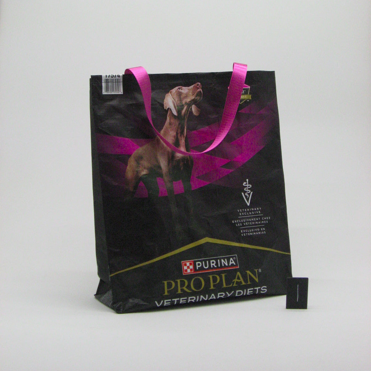 A black Purina ProPlan Veterinary Diets shopping bag with pink handles and a dog graphic, photographed on a light gray background.